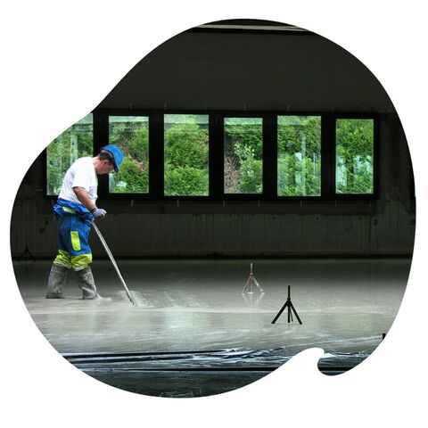 Guide - Chape liquide Professionnel en train d'appliquer une chape fluide sur une grande superficie
